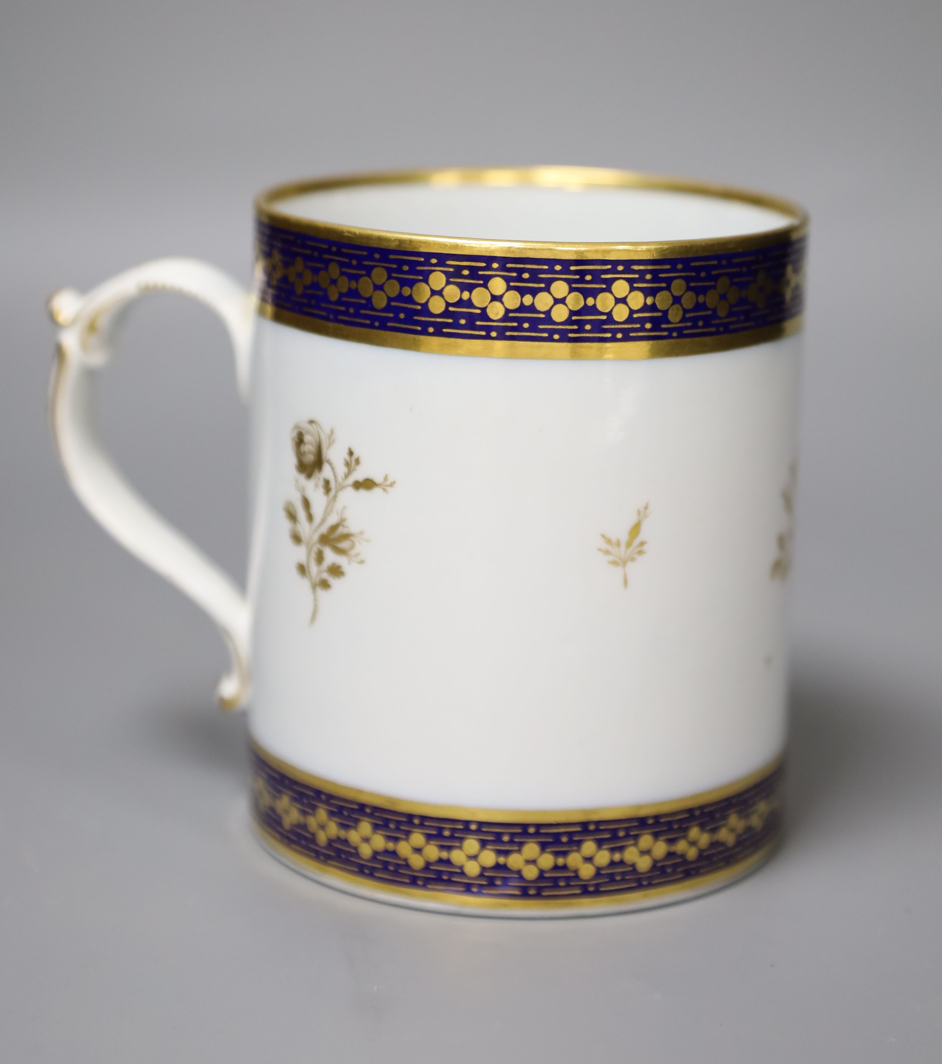 A 19th century Barr Worcester fine mug with a distinctive handle painted in under glaze blue and gilded with floral sprays, height 11cm